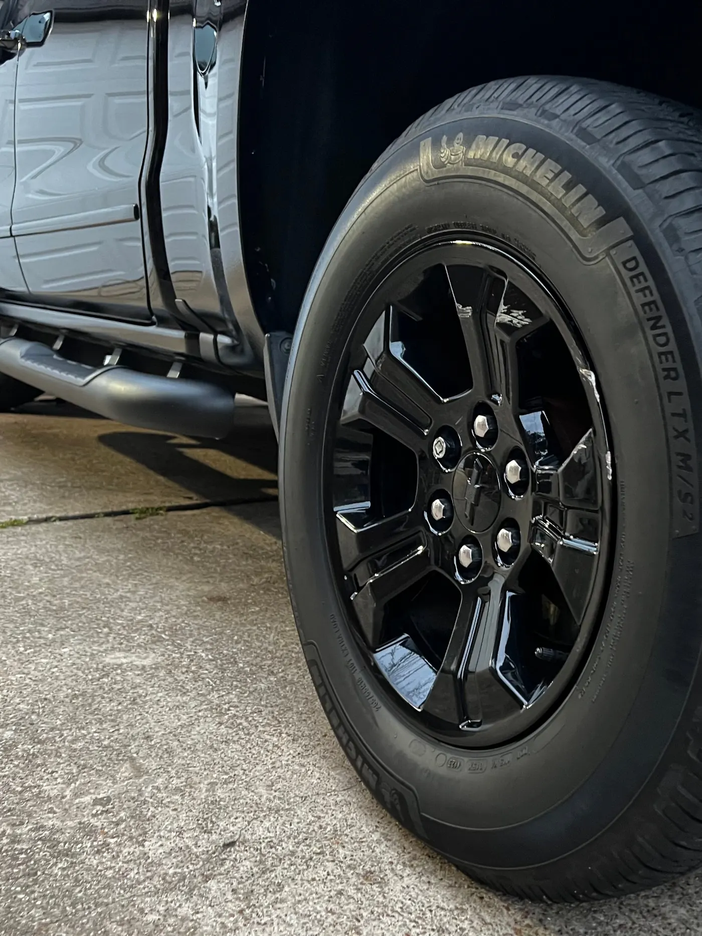Chevy Silverado glossy black wheel and Michelin tire close-up